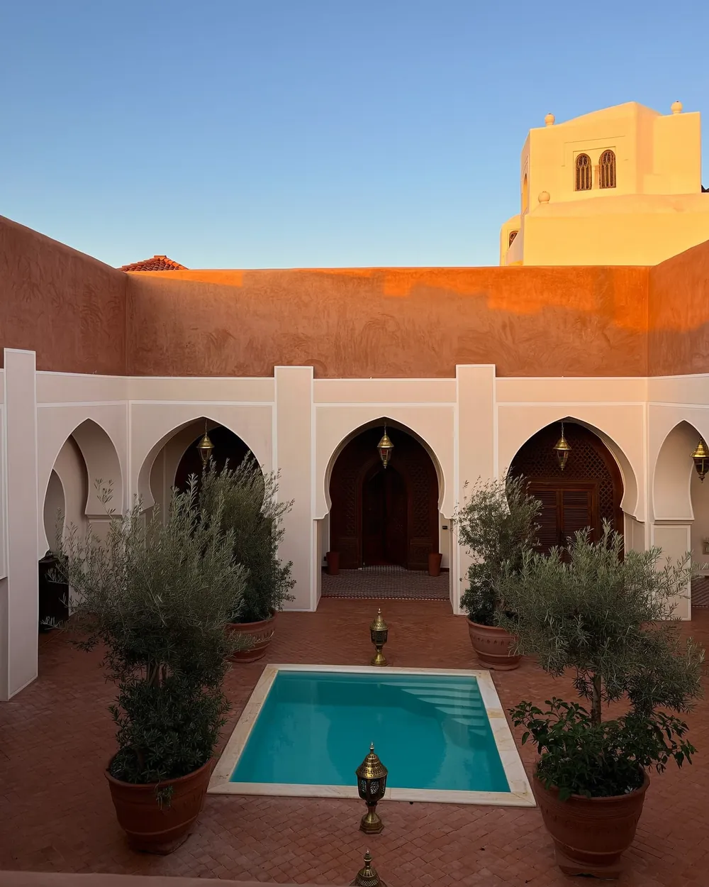 Patio de riad avec piscine à Marrakech au coucher du soleil